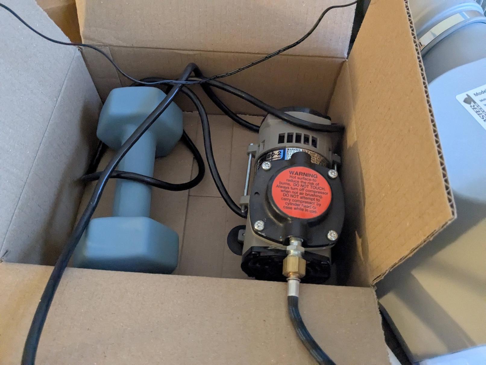 Air compressor in a box with a weight