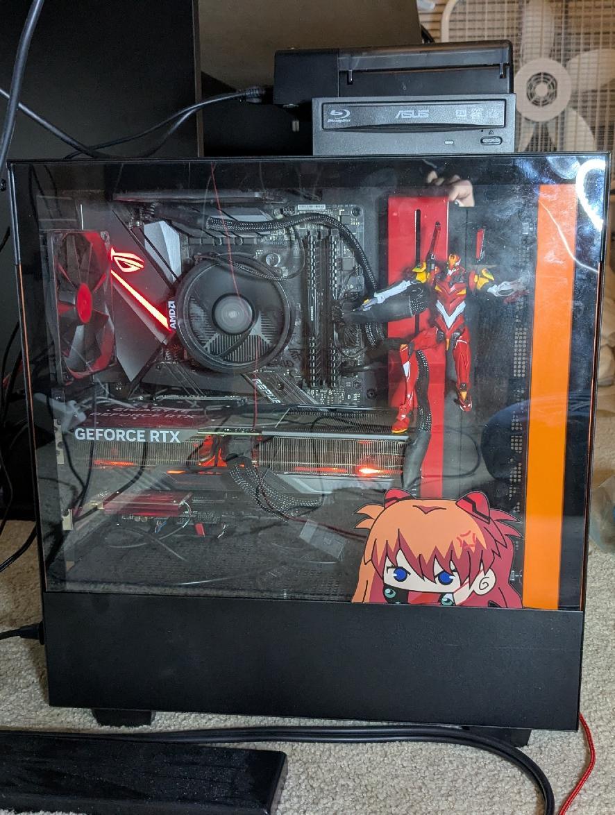 Desktop case with Asuka sticker and Unit 02 model kit posed inside it